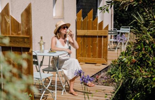 a woman sitting at a table with a drink at Hotel Le Branhoc - Brit Hotel Auray in Auray