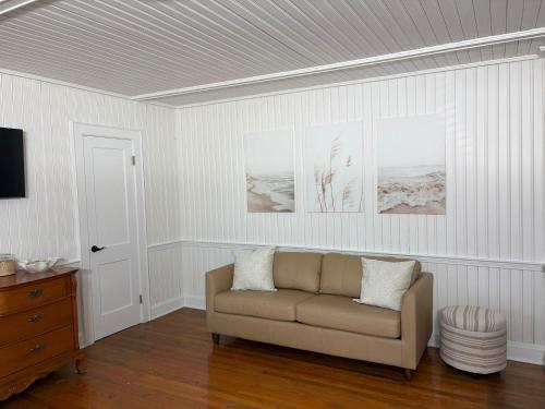 a living room with a couch and pictures on the wall at 02-Sandbar Suite at The Castle Inn in Ocracoke