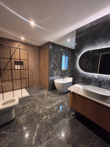 a bathroom with two sinks and a tub and a toilet at Moate View House in Ballymore Eustace