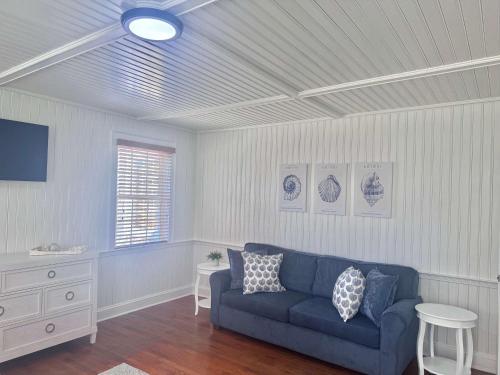 a living room with a blue couch and a table at 04-The Seashell Suite at The Castle Inn in Ocracoke