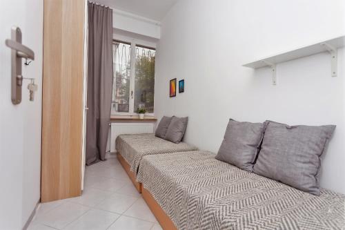 a small bedroom with a bed and a window at Cozy Downtown Rooms in Warsaw