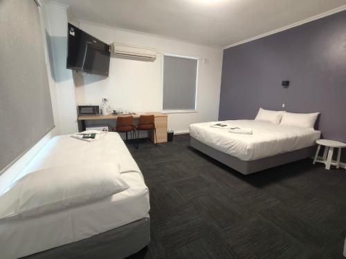 a hotel room with two beds and a tv at Tintinara Hotel in Tintinara