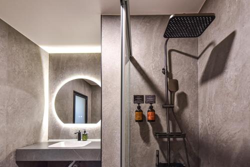 a bathroom with a sink and a mirror at 貳宿文旅 in Tainan