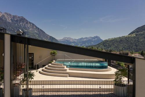 a house with a swimming pool and mountains in the background at Amaris Suites Rabland, Südtirol in Rablà