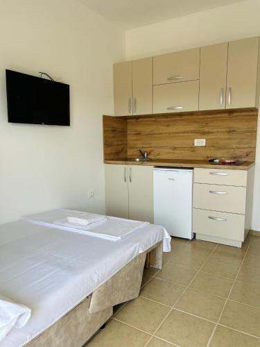 a room with a kitchen with a bed and a tv at Apartmani ,,Del Mar'' in Ulcinj