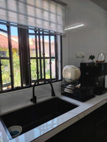 a kitchen counter with a sink and a window at Maileyna Homestay 3 in Alor Setar