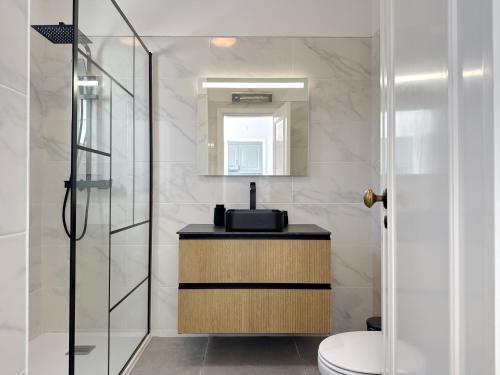 a bathroom with a sink and a toilet and a mirror at Sunset Haven Algarve in Albufeira