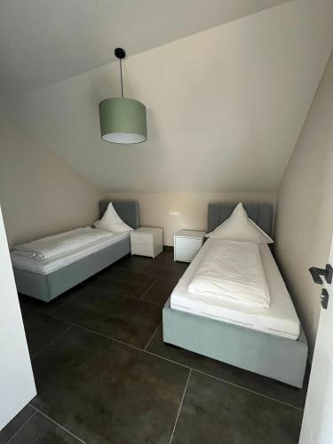 two beds in a room with a ceiling at Apartment by Ela in Alpirsbach