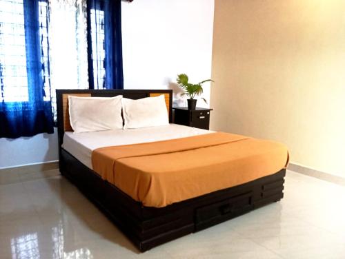 a bedroom with a bed with an orange blanket at Happy Stay in Vagamon