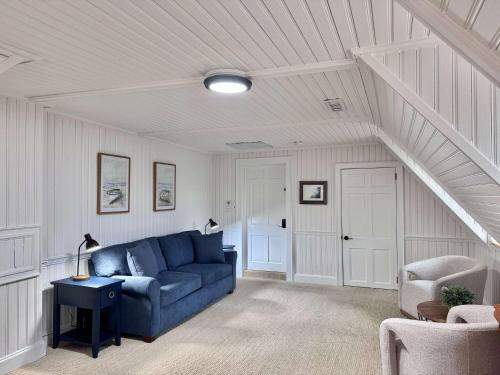 a living room with a blue couch in a attic at 07-Founders Suite at The Castle Inn in Ocracoke