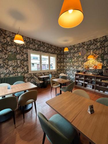 a restaurant with tables and chairs in a room at Hôtel de Caen in Caen