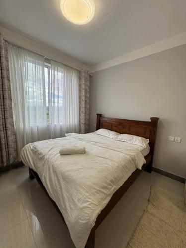 a bedroom with a large bed with a large window at Jambo luxury living in Marimbeti
