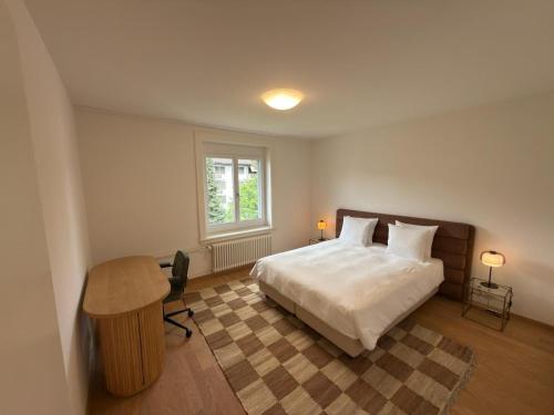 a bedroom with a bed and a desk and a window at Stadtloft Suites Zürich- Oerlikon in Zurich