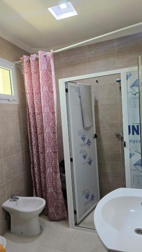 a bathroom with a toilet and a shower and a sink at Appement in Agadir nʼ Aït Sa