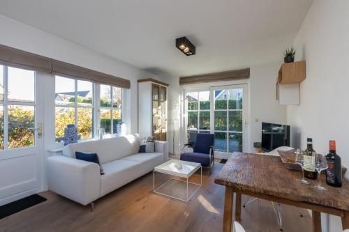 a living room with a white couch and a table at Welcome in - Appartement met zonnig terras, nabij centrum Zoutelande I Borne 56a in Zoutelande