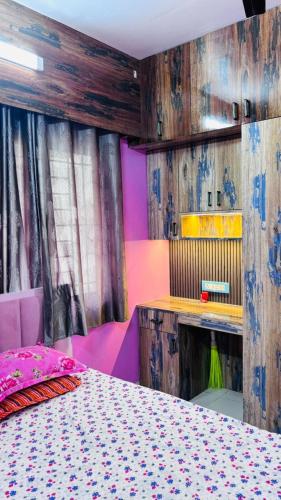 a bedroom with a bed and a wooden wall at Kaushani Homes in Nangi