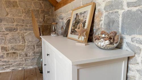 a white table in a room with a stone wall at Stone house Olsavinia close to the beach in Kaštela