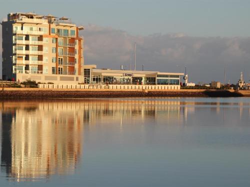 a large body of water with a large building at Wallaroo Marina Luxury Apartment in Wallaroo