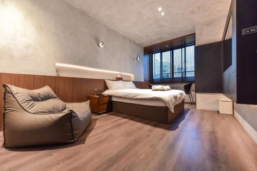 a bedroom with a bed and a couch at 貳宿文旅 in Tainan