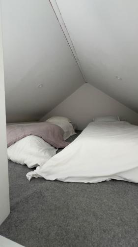 two beds in a room with white walls at Scandinavian Guesthouse, Archipelago Escape in Vaxholm