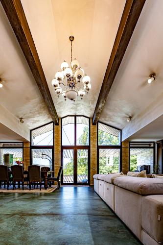 a large living room with a chandelier and a table at Breite Privée Forest and Pool Retreat in Sighişoara