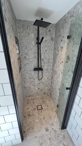 a shower with a cross hanging from the ceiling at Scandinavian Guesthouse, Archipelago Escape in Vaxholm