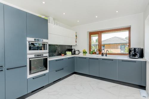 a kitchen with blue cabinets and a window at Valgekodu Pesa in Papsaare