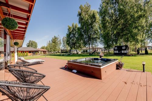 a hot tub on a patio with two chairs at Valgekodu Pesa in Papsaare