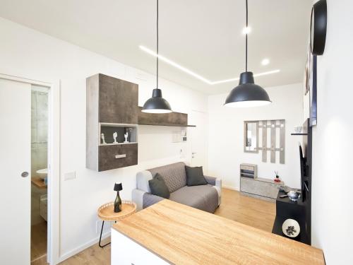 a kitchen and living room with two pendant lights at La Terrazza del Gabbiano in Cozze