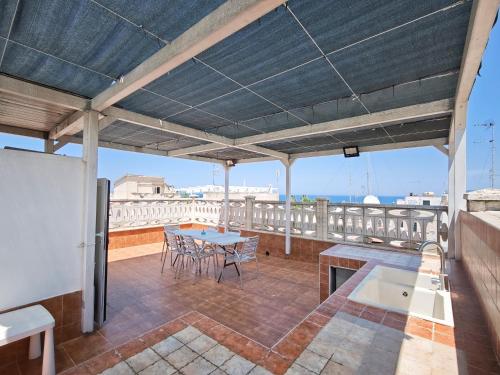 a patio with a table and chairs on a roof at La Terrazza del Gabbiano in Cozze