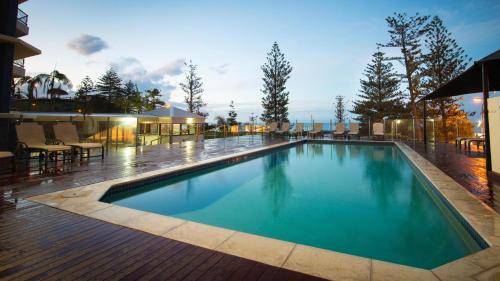 a swimming pool with blue water on a building at Beach House Seaside Resort in Gold Coast