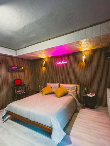 a bedroom with a bed with neon lights on the wall at Smith's house in Borgo San Dalmazzo