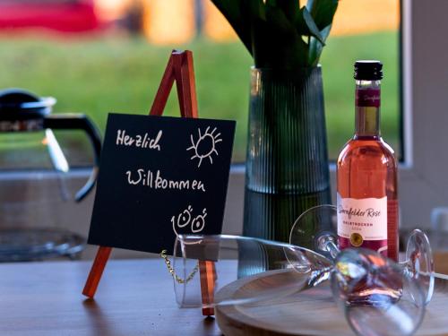 a bottle of wine and a sign on a table at EifelRuhe 3 in Hellenthal - ideal für Familien und Paare mit Hund - voll ausgestattete Küche und zwei Schlafzimmer in Hellenthal