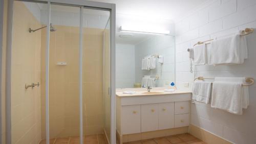 a bathroom with a shower and a sink and a mirror at Cedar Lake Country Resort in Nerang