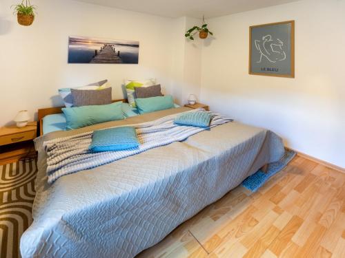 a bedroom with a large bed with blue pillows at EifelRuhe 3 in Hellenthal - ideal für Familien und Paare mit Hund - voll ausgestattete Küche und zwei Schlafzimmer in Hellenthal