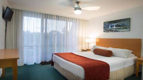 a hotel room with a bed and a large window at Cedar Lake Country Resort in Nerang