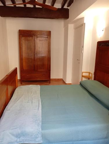 a bedroom with a large bed and a wooden cabinet at La finestra sulla campana in Brescello