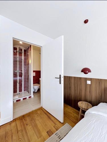 a bedroom with a door leading to a bathroom at Maison Plage - boutique hôtel in Saint-Brevin-les-Pins