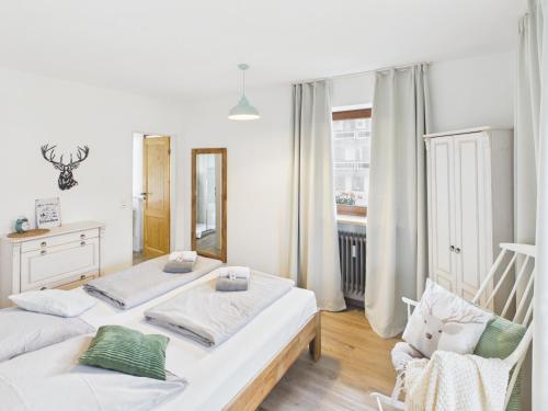 two beds in a room with a mirror and a chair at Alpenblick 5 - Chiemgau Karte in Inzell