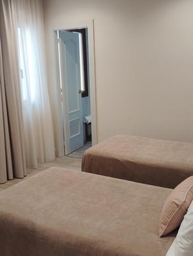 a room with two beds and a door to a bedroom at Hotel Vélez in Vélez-Rubio
