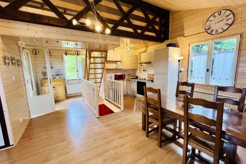 a kitchen and dining room with a clock on the wall at Chalet le Petit Coeur in Xonrupt-Longemer