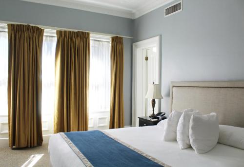 ein Schlafzimmer mit einem großen Bett und weißen Kissen in der Unterkunft The Priory Hotel in Pittsburgh