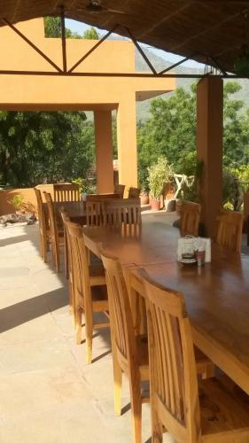 a large wooden table and chairs under a pavilion at Krishna Ranch in Udaipur