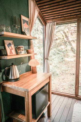 a room with a wooden table with a tv and a window at Minimökki Karjalohjalla in Lohja
