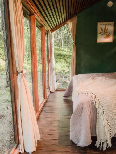 a bedroom with a bed and a large window at Minimökki Karjalohjalla in Lohja