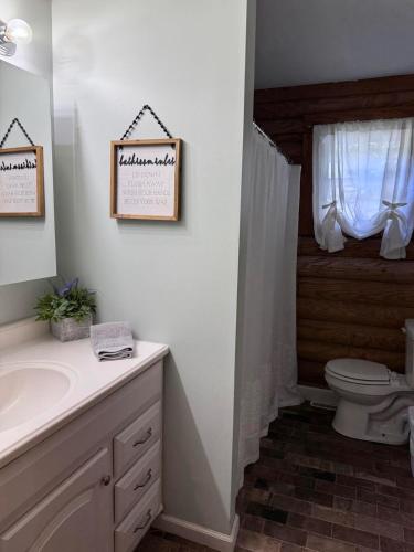 a bathroom with a toilet and a sink and a window at The Shack in Oak Hill