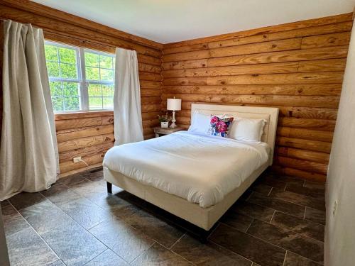 a bedroom with a bed in a room with wooden walls at The Shack in Oak Hill