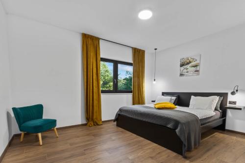 ein Schlafzimmer mit einem Bett und einem grünen Stuhl in der Unterkunft Vila Prisunca with jacuzzi & swimming pool in Pazin