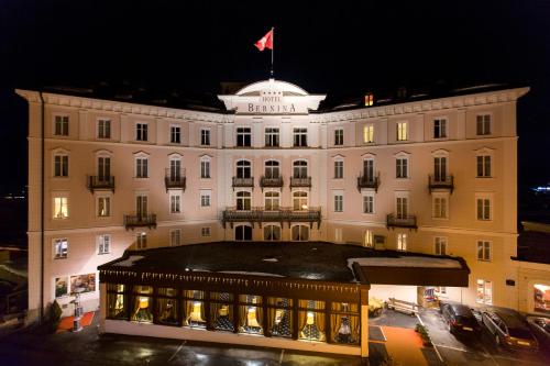 a large white building with a flag on top of it at TH Samedan - Hotel Bernina 1865 in Samedan