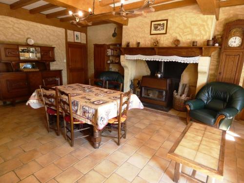 a living room with a table and a fireplace at Maison lacabane in Saint-Sever